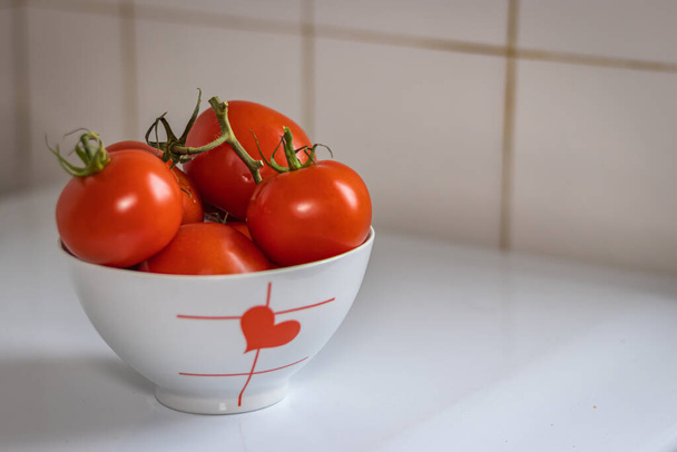 Tomates rojos maduros en la cocina en un tazón - Foto, Imagen