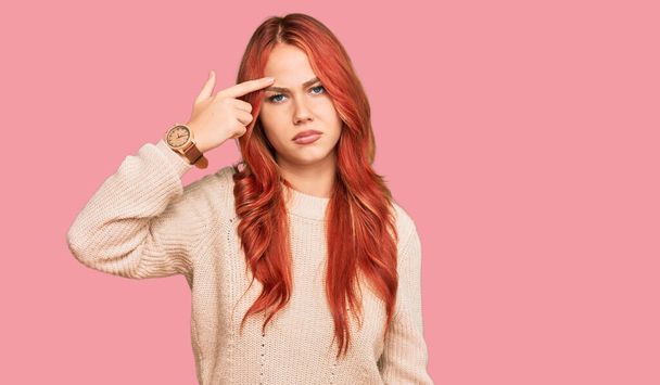 若い赤毛の女性が額ににきびに不幸なポインティングカジュアルな冬のセーターを着て、黒頭の醜い感染症。にきびや皮膚の問題  - 写真・画像