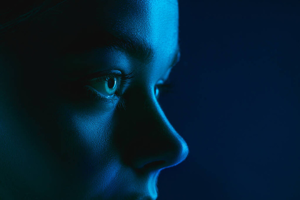 Portrait of female fashion model in neon light on dark studio background. - Foto, Bild