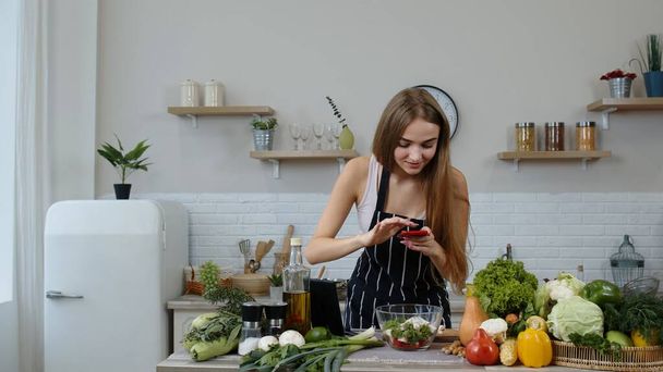 Mujer bloguera preparando comida, tomando fotos en el teléfono para sus cuentas sociales o historias de video - Foto, imagen
