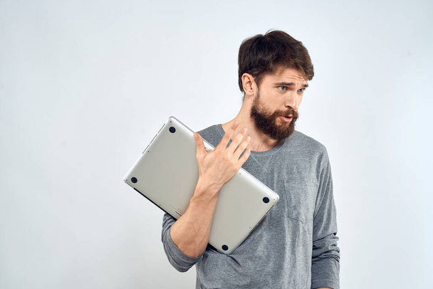 Hombre con portátil en las manos tecnología internet confianza en sí mismo luz de fondo - Foto, imagen