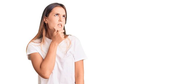 Beautiful caucasian woman wearing casual white tshirt thinking worried about a question, concerned and nervous with hand on chin  - Foto, immagini