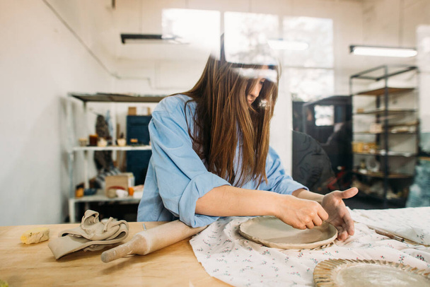 young woman, potter, makes utensils with their own hands in their own workshop - Фото, зображення
