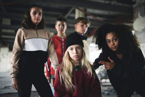 Group of teenagers gang standing indoors in abandoned building, bullying concept. - Fotoğraf, Görsel