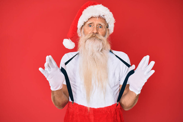 Vanha vanhempi mies yllään joulupukin puku henkselit rento vakava ilme kasvoilla. yksinkertainen ja luonnollinen kameraan katsominen.  - Valokuva, kuva