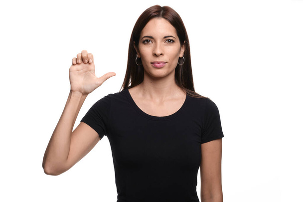 Isolated in white background brunette woman saying letter E in spanish sign language - Foto, imagen