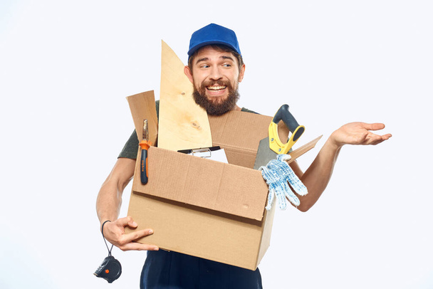 手工具配送サービスライトバックグランドのボックスと一致する労働者の男 - 写真・画像