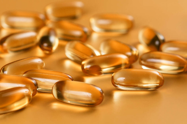 Veel capsules Omega 3 op gele achtergrond. Close-up, product met hoge resolutie. Gezondheidszorgconcept. - Foto, afbeelding