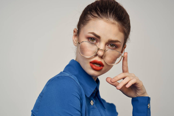 Portrait of emotional woman in blue shirt and glasses bright makeup model light background cropped view Copy Space - Photo, Image