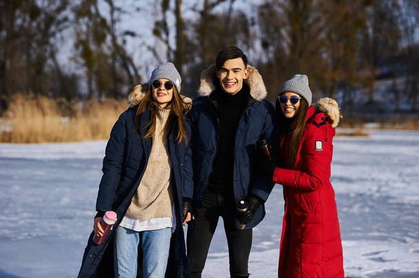 Young friends having fun outdoors in winter time. Concept of friendship and fun with new trends - Foto, Imagen