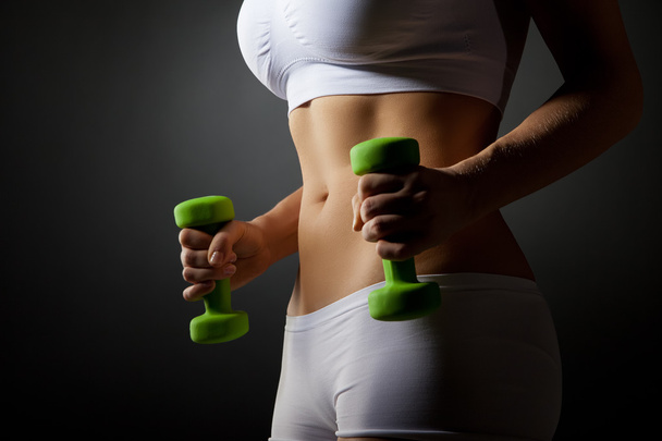 Young woman lifting dumbbell - Foto, afbeelding