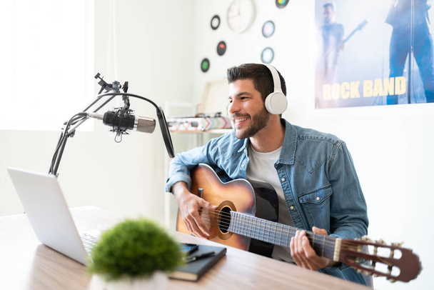 Blogger and radio host playing a song and singing for some of his fans during a live podcast for social media - 写真・画像