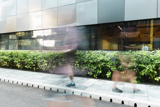 motion blur of people walking on street near modern building  - Foto, Imagen
