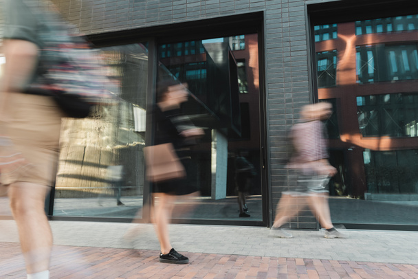 citizens walking on modern street near building, motion blur  - Photo, Image