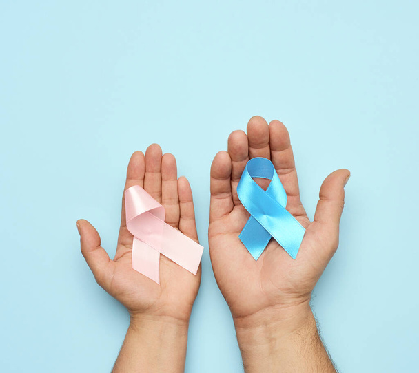 naisten käsi vaaleanpunainen nauha keula, mies käsi tilalla sininen nauha. Rintasyövän valistuskampanjan käsite ja eturauhassyövän torjunnan ja hoidon symboli, ylhäältä - Valokuva, kuva