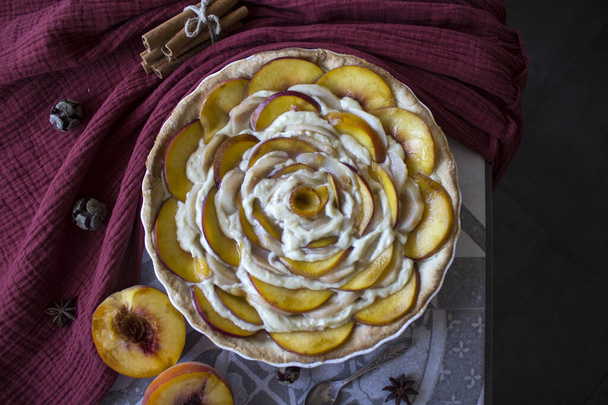 新鮮な桃とクリームと花の形のパイ。自家製デザートトップビューの写真. - 写真・画像