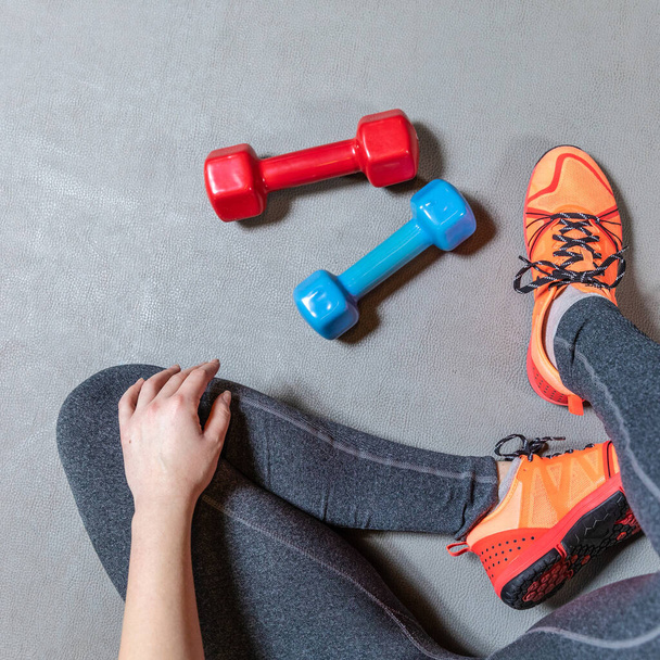 Fitness woman legs with colorful dumbbells top view - Photo, Image