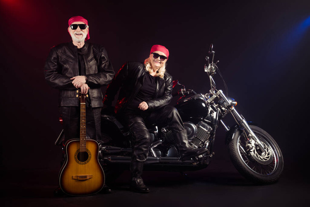 Full length photo of old two cool bikers man lady sit chopper rock festival play guitar famous popular metal band meeting wear trendy rocker leather outfit isolated black color background - Photo, image
