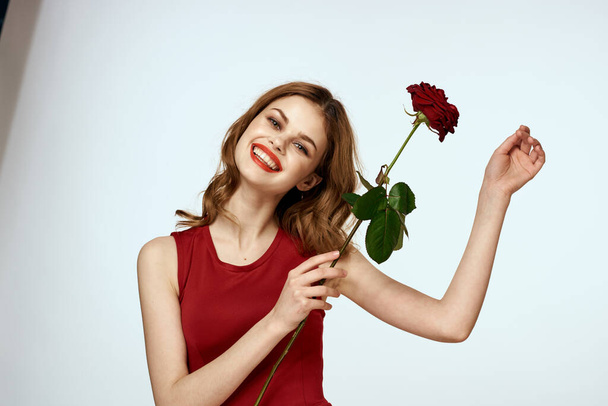 Pretty woman with rose in her hands charm gift lifestyle studio light background - Fotó, kép