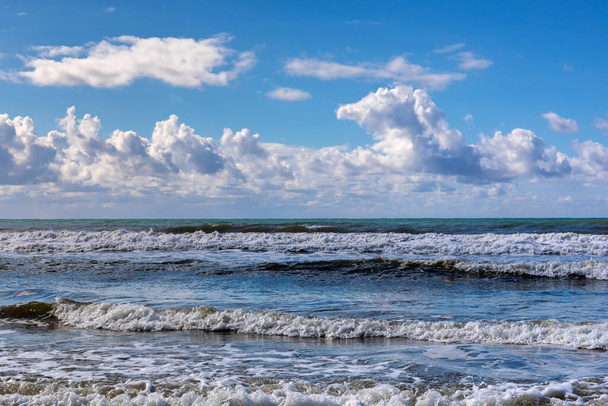 Winter beach, sea waves and cloudy sky. - Foto, afbeelding