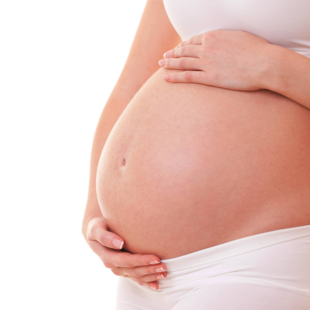 Image of pregnant woman touching her big belly. Close up. Motherhood, pregnancy, people and expectation concept. Pregnant woman expecting baby - Photo, image