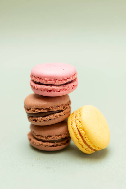 Pile of colored tasty macaroons over a green background. - Foto, imagen