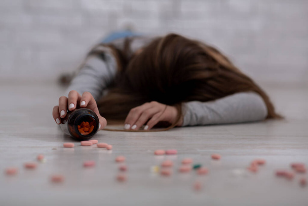 Senhora milenar cometendo suicídio por overdose em antidepressivos, foco seletivo na mão segurando frasco de pílulas - Foto, Imagem