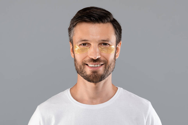 Mann mittleren Alters mit goldenen Flecken unter den Augen von Falten - Foto, Bild