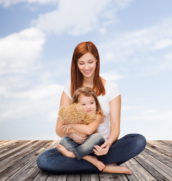 Happy mother with adorable girl and teddy bear - Foto, afbeelding