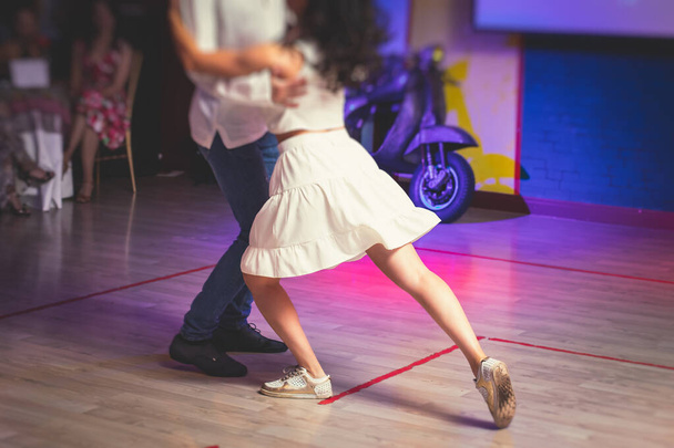 Couples dancing traditional latin argentinian dance milonga in the ballroom hall, tango salsa bachata lesson in the red lights, dance festiva - Fotografie, Obrázek