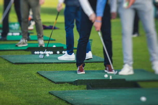 Groep golfers oefenen en trainen golf swing op driving range praktijk, mannen spelen op de golfbaan, golfbal op golfcomplex clubresort, zomer zonnige da - Foto, afbeelding