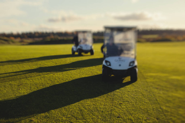 Golf electric cars riding on a golf course in the day, golf carts drive with golfers in resort clu - Zdjęcie, obraz