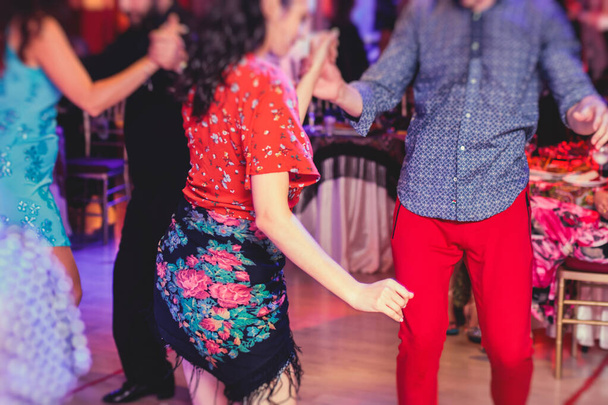Couples and women wearing red skirts and dress dancing traditional gypsy dance in the ballroom hall club - Fotografie, Obrázek