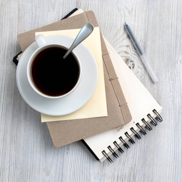 desk office with blank notepad, coffee cup and pen on wood table. Flat lay top view copy space. Top view - Zdjęcie, obraz