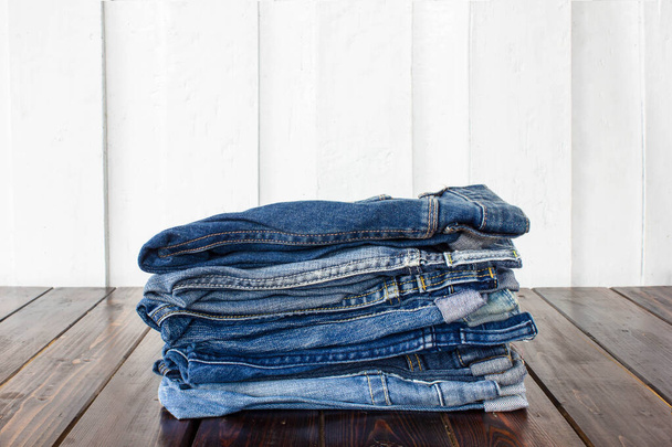 Jeans gestapelt auf einem hölzernen Hintergrund - Foto, Bild