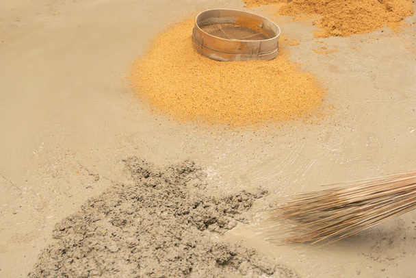 Индийские строительные работы отделили песок и гравий вручную с помощью сита, для использования песка для цементирования работы, Изображение снято на Howrah, Западная Бенгалия, Индия. - Фото, изображение