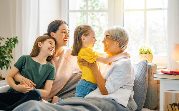 A nice girls, their mother and grandmother enjoying spending time together at home.  - Photo, image