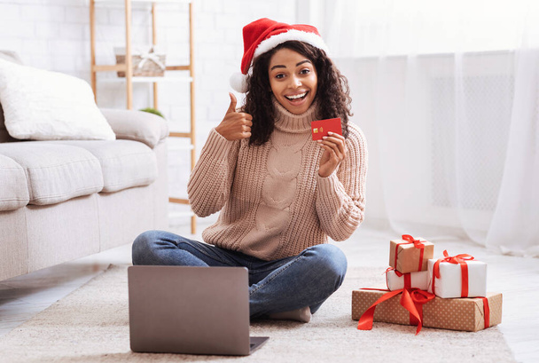 Різдвяні покупки. Чорна дама використовує ноутбук, що тримає кредитну картку
 - Фото, зображення