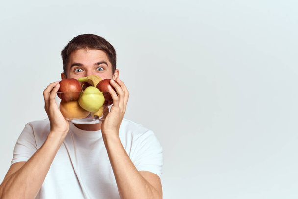 άνθρωπος με φρέσκα φρούτα σε ένα γυάλινο κύπελλο gesturing με τα χέρια βιταμίνες ενέργεια μοντέλο φουντωτό μουστάκι γενειάδα - Φωτογραφία, εικόνα