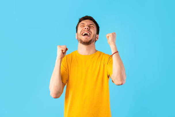 Portrait of happy man screaming with raised fists - Фото, изображение