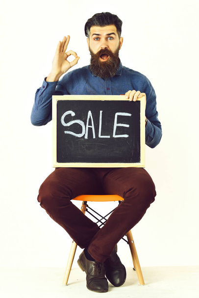 Bearded man, brutal caucasian hipster with moustache holding sale inscription - Photo, image