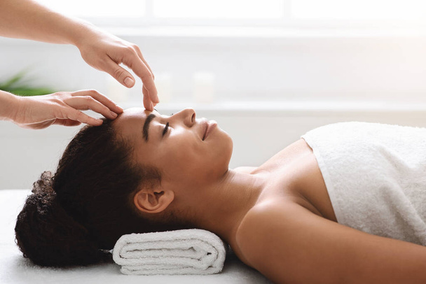 Terapeuta spa fazendo relaxante massagem na cabeça para jovem bela senhora - Foto, Imagem