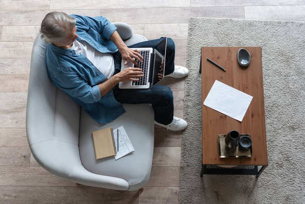 Middle-aged man working from home-office on laptop. - Photo, image