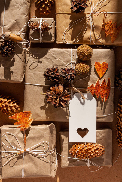 廃棄物ゼロクリスマスは、ハード影と平らなレイアウトをノリング。手作りのエコギフト、自然の新年のジュートの装飾トップビュー。プラスチックの概念なしでクラフト紙包装。オレンジの皮の木のハートコーン - 写真・画像