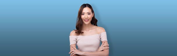 Portrait of Fashion 20s Asian Woman has beautiful update make up color lipstick, she wear pastel pink Fashionable items, strong feeling poses over blue Background isolated copy space banner - Foto, Bild