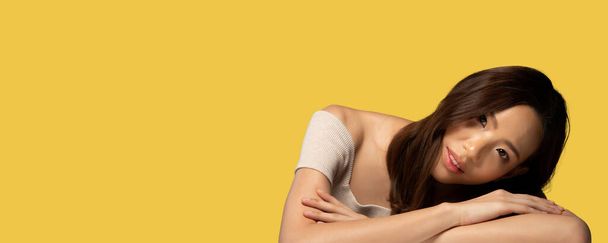 Portrait of Fashion 20s Asian Woman hat schöne Update Make-up Farbe Lippenstift, sie tragen pastellrosa Modische Artikel, starkes Gefühl posiert über gelb Hintergrund isoliert Kopierraum Banner - Foto, Bild