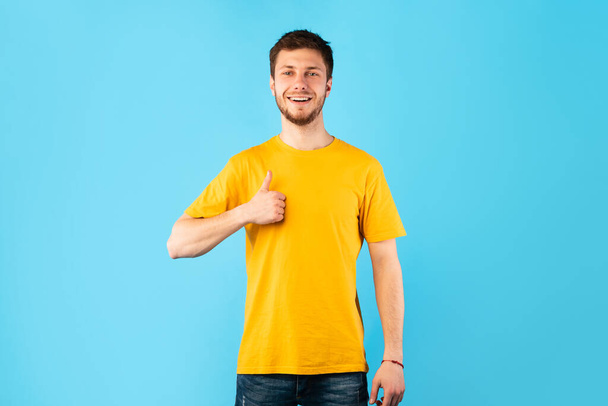 Happy man gesturing thumbs up and smiling - 写真・画像