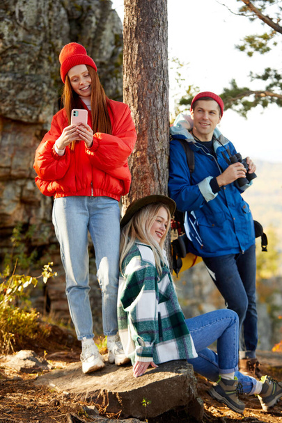 three caucasian friends enjoy spending time in the forest after climbing mountains - Photo, image