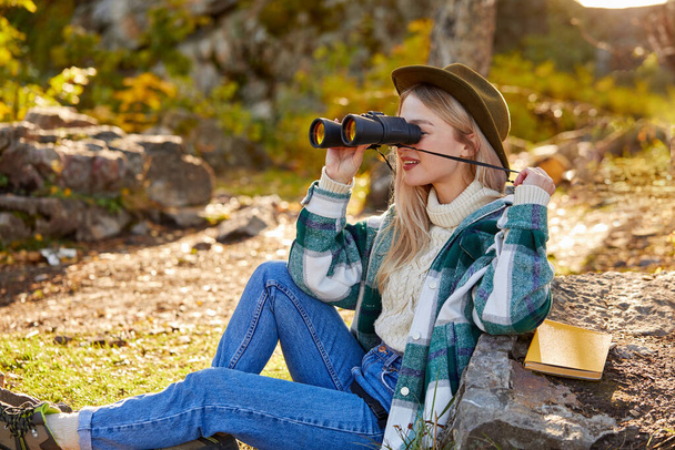 young happy blonde woman enjoying autumn outdoors, use binoculars - Fotó, kép