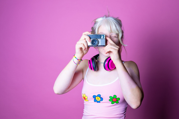 Junge schöne kaukasische Frau beim Fotografieren mit Retro-Vintage-Fotokamera auf rosa Hintergrund - Diverse weibliche isolierte Studioaufnahmen mit Kamera - Fotografie, Technik, Erinnerungskonzept - Foto, Bild